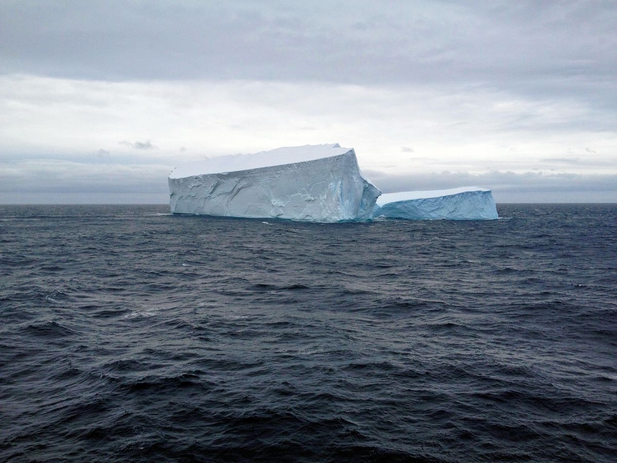 Iceberg em mar aberto com céu nublado, representando os custos ocultos do programa de viagens