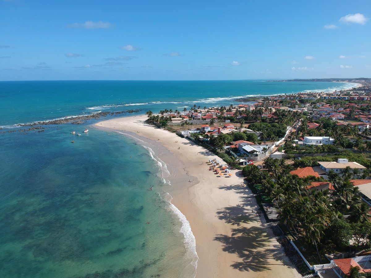 Vista aerea da praia de Ponta Negra em Natal com mar azul e hoteis, representando eventos corporativos em Natal