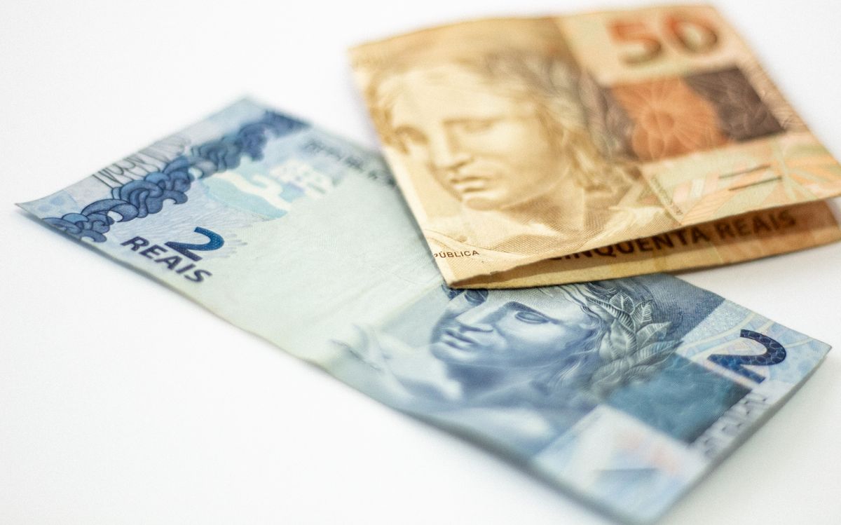 Cédulas de 2 e 50 reais sobre fundo branco, representando o saldo orçamentário de fim de ano
